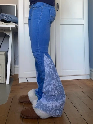Lågmidjade jeans med spets - Säljer dessa så fina och unika jeans som är omsydda till bootcut med spets. Midjemått 37 cm och innerbenslängd 75 cm. Obs hunden är ej till salu🤗🤗💕