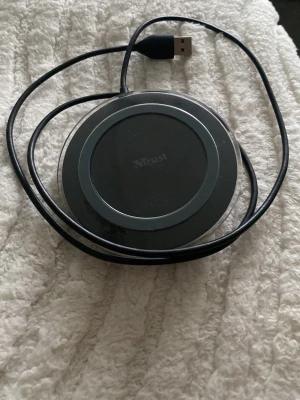 Trust trådlös laddare svart USB - Rund trådlös laddare från Trust i svart plast med USB-kabel. Passar till mobiler som stödjer trådlös laddning. Smidig och enkel att använda, bara koppla in och ladda din telefon utan sladdar. 