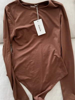 Brun långärmad body från Bianca, S - Helt ny och oanvänd body från Bianca Collection. Mjuk och följsam kvalitet med lång ärm och stilren design. Finns även matchande byxor