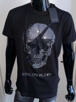 Philipp Plein T-Shirt-Svart,Strl M - Helt ny. Fin replika med hög kvalitet. EU| M Normal i passform. Först till kvarn som gäller ä. Skickas direkt inom 24h
