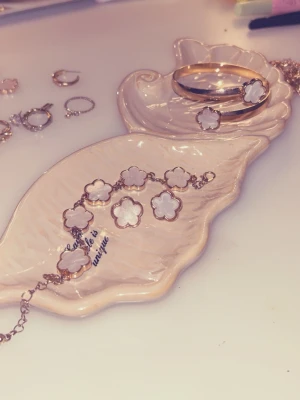 Två armband och ett par örhängen - Säljer ett tjockt guld armband med två vita blommor på. Ett guld kedjearmband med flera vita blommor på och ett vitt par blomörhängen. Jätte fina att matcha. Råkade köpa dubbletter så säljer detta par. Allt för 40kr. Om ni vill ha separat kontakta mig. Pris kan diskuteras. 😊 Gå in på mitt konto jag säljer FLERA smycken i olika former och färger. 