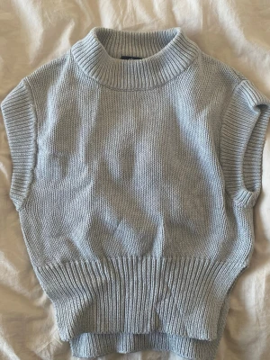 Ljusgrå stickad väst från Gina Tricot - Säljer en kortare ljusgrå stickad väst från Gina Tricot, med hög krage och bred ribbstickad kant nedtill. Såå fin nu till våren 💗🌷🥰