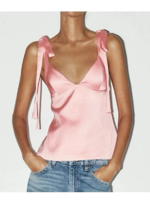 Rosa satinlinnetopp med knytband - Supersöt rosa linnetopp i satin med smala axelband som knyts till rosetter. Djup v-ringning framtill och lätt glansigt material ger en lyxig känsla. Perfekt att styla med jeans eller kjol för en trendig look.