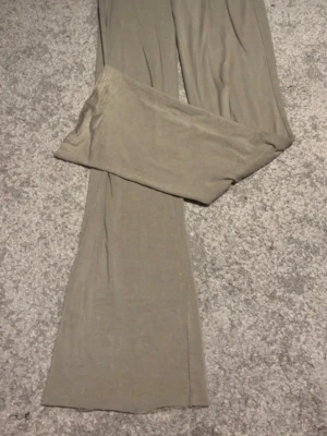 Beige vida leggings - Säljer ett par beige leggings med utsvängda ben. De är tillverkade i ett mjukt och stretchigt material som sitter skönt på kroppen. Perfekta för dig som gillar en avslappnad och trendig stil.