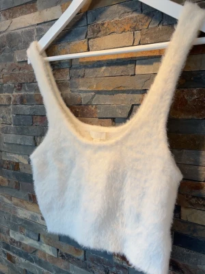 Vit fluffig croppad linnetopp - Hej!☀️Säljer denna supersöta fluffiga toppen med en croppad passform. Toppen har breda axelband och rundad halsringning, perfekt både till jeans eller kjol, eller en myskväll hemma.💕Helt oanvänd utan lapp🫶