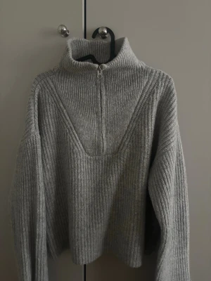 Grå stickad tröja från Bik Bok - Grå stickad tröja från Bik Bok med hög krage och halv dragkedja framtill, väldigt fin och varm🫶