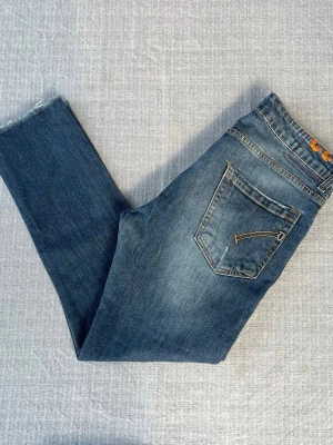 Blå Dondup George jeans med slitningar och fades, storlek 32 - Blå Dondup George jeans med feta slitningar och schyssta fades En liten fläck som knappt märks Hör av er vid frågor!