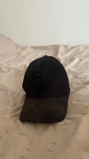 Svart White Sox keps Flexfit - Säljer en svart keps från Flexfit med White Sox-logga broderad framtill. Klassisk böjd skärm och brottarinspirerad passform. Tillverkad i bomullsmix med elastiskt band på insidan för extra komfort. Perfekt för dig som gillar sportig streetstyle. Den har blivit lite solbränd men värre i kamera än verklighet 