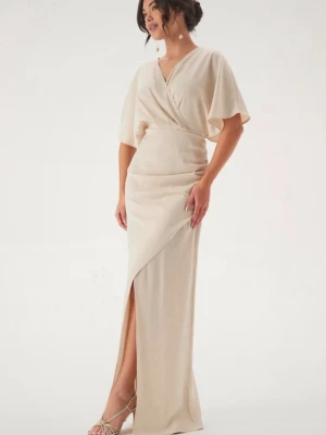 Beige balklänning med slits - Elegant långklänning i beige med omlott-design och v-ringning. Klänningen har korta, vida ärmar och en slits framtill som ger en snygg touch. Perfekt för dig som vill ha en stilren och modern look. Köpt från bubbleroom i storlek S. Använt vid ett tillfälle endast 