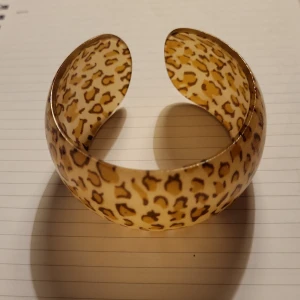 Bred leopardmönstrad armbandsbåge - “Stilrena och trendiga breda C-formade armband i resin med elegant leopardmönster och unika, djärva geometriska detaljer – ett iögonfallande smycke som ger din stil en modern och exklusiv touch.”