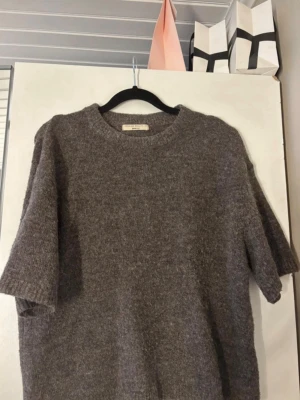 Brun stickad tröja Gina Tricot - Mysig brun stickad tröja från Gina Tricot i premiumkvalitet. Tröjan har korta ärmar, rund halsringning och är gjord i ett mjukt, luddigt material som känns riktigt skönt mot huden. Perfekt för lager på lager och en avslappnad look. Priset är diskuterbart!