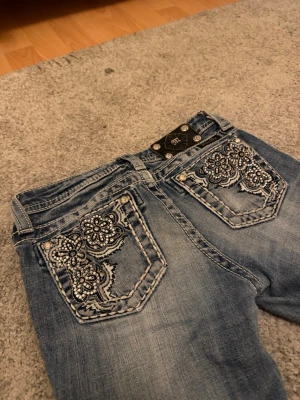 Bootcut blommiga miss me jeans - Säljer tyvärr dessa jätte jätte fina miss me jeansen då de inte passar mig längre:(( De har funnits med ett tag och visar lite svagt slitage vid fötterna, men är i perfekt skick annars! Storleken är ”12” men skulle säga att de passar som XXS + nån som är lite kortare💓 kom med bud!