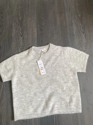 Grå stickad t-shirt från Gina tricot  - En enkel och stilren grå stickad t-shirt från Gina. 