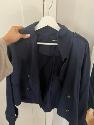 Kort mörkblå trenchcoat från Gina Tricot - Snygg och trendig mörkblå trenchcoat från Gina