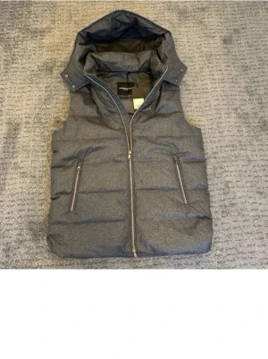 Grå dunväst med luva - Säljer nu en grå dunväst med luva. Helt perfekt för våren och säljer den för galet bra pris!! Hör av er vid frågor eller funderingar.MVH
