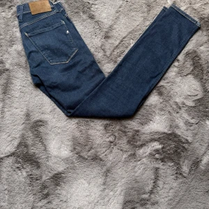 Mörkblå Replay anbass jeans - Snygga mörkblå jeans från Repaly. Tillverkade i stretchigt denimtyg för extra komfort. Perfekta för en trendig och avslappnad look. W27 L32. Priset är ej hugget i sten, hör av dig vid minsta fundering!✨