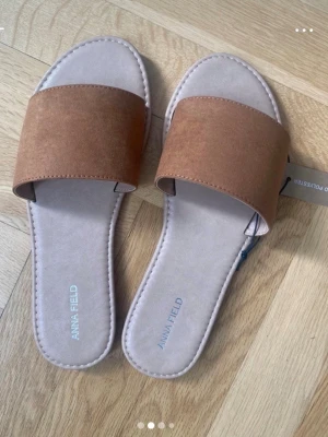 Oanvända slip-in sandaler  - Snygga slip-in sandaler från Anna Field. Helt oanvända. Minimalistisk design som passar perfekt till sommaren. Sköna att bära och lätta att matcha med olika outfits.