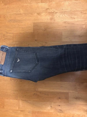 Blå jeans från Armani - Snygga blå jeans från Armani med klassisk fickmodell och diskret logga på bakfickan. Jeansen har en tvättad look med lätt slitningar och raka ben. Tillverkade i mjukare denimtyg som ger en skön passform.