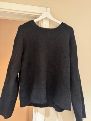 Svart stickad tröja från BikBok - Mysig svart stickad tröja från BikBok med rund halsringning och avslappnad passform. Tröjan har långa ärmar och ribbade muddar vid ärmslut och nederkant. Skriv vid frågor!🩷