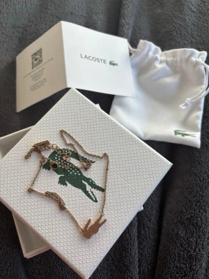 Guld halsband från Lacoste - Guld halsband från Lacoste. Knappt använd. Ingen tecken på användning. Skriv för mer bilder!!