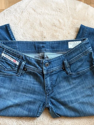 Y2k Diesel low waist mom jeans  - Snygga blå jeans från Diesel med klassisk femficksmodell och raka ben. Jeansen har en diskret tvättad look och detaljerade sömmar. Tillverkade i bomull med en liten mängd elastan för extra komfort. Perfekta för en avslappnad och trendig stil.