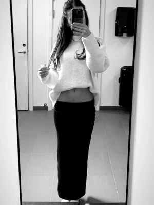 Svart långkjol i mjukt material - Enkel och stilren svart långkjol med rak passform. Kjolen är i ett mjukt, stretchigt material som sitter snyggt på kroppen. Perfekt att matcha med en crop top eller stickad tröja. Inga synliga detaljer eller mönster. Använd fåtal gånger.