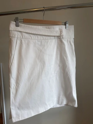 Vintage Yves Saint Laurent Rive Gauche Kjol - Säljer denna otroliga vintagekjol från Yves Saint Laurent Rive Gauche! Den är tillverkad i Frankrike och har en helt unik, asymmetrisk vikt detalj i linningen. Den är i en fräsch vit nyans och i fantastiskt vintageskick utan några fläckar eller defekter vad jag kan se. Det är ett så sällsynt plagg, men jag har tyvärr inte rätt tillfällen att använda den, så jag hoppas den kan få ett nytt kärleksfullt hem. 