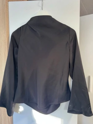 Svart satin topp  - En otroooligt fin satin topp! Passar till allt och är otroligt skön och behaglig att ha på sig. Man knyter bak på som gör att den blir lite öppen i ryggen 