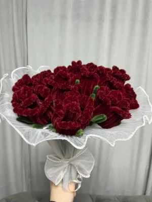 Bukett med vinröda tygrosor - Säljer en bukett med vinröda konstgjorda rosor i sammetstyg. Blommorna har gröna tygblad och är inslagna i ett vitt, vågigt dekorationspapper med rosett. Perfekt som dekoration eller present.