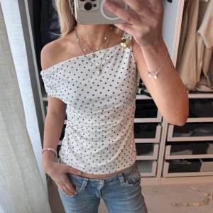 Vit prickig polka dot festtopp - Så snygg vit prickig / polka dot fest topp, off / one shoulder med guld detalj från river Island. 