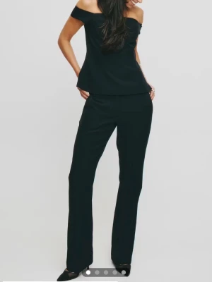 Svarta flare kostymbyxor - Stilren svart kostymbyxa med raka ben. Snygg passform som framhäver benen och ger en elegant siluett. Materialet ser ut att vara mjukt och följsamt, perfekt för dig som gillar en modern look.