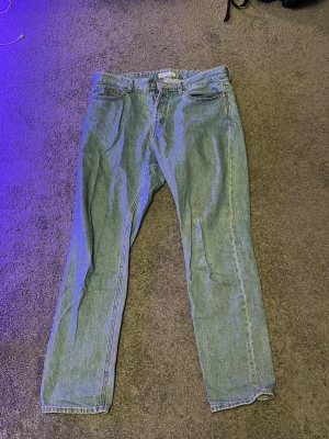 Blå raka jeans regular fit 34/32 - Klassiska blå jeans i regular fit med raka ben. Jeansen har en enkel design utan slitningar och är tillverkade i ett styvt denimtyg. Passar perfekt för dig som gillar en tidlös och clean look.