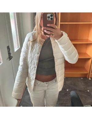 !ROSA! uniqlo inspirerad jacka - Säljer en stilren rosa pufferjacka med rund hals och diskreta sömmar. Jackan är lätt och har en klassisk passform som är perfekt för kalla vinterdagar. Materialet ser ut att vara syntetiskt och jackan saknar synliga loggor eller märken.