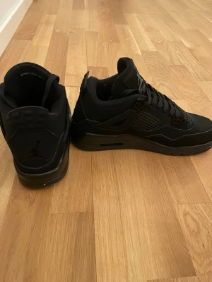 Svarta Air Jordan 4 Retro sneakers - Säljer ett par helsvarta Air Jordan 4 Retro sneakers med klassisk siluett. Använd några gånger, säljer pga att dem är för små!