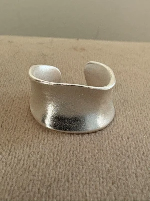 Handgjord Silver 925 Sterling Ring - Bred, Buckled - Justerbar  - Handgjord Silver 925 Sterling Ring - Bred, Buckled  - Material: Äkta Sterling Silver (925-silverstämpel)   - Design: Handgjord, Bred, Buckled - Passar: Kvinna – justerbar/bekväm passform   - Skick: Helt ny   - Frakt: Alltid snabb leverans   💫 Se även mina övriga annonser för fler stilrena silverringar. Mängdrabatt tillämpas 💫