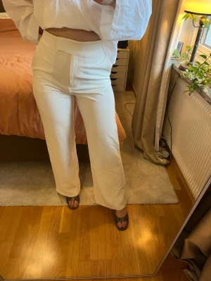 Vita kostymbyxor med hög midja - Kostymbyxor med hög midja och raka ben. Bred linning och dold dragkedja. storlek 42. Innebenlängd 75cm