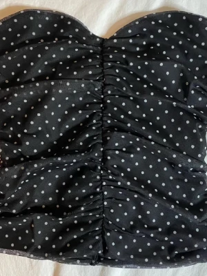 Svart prickig bandeau topp - Supersnygg svart bandeau topp med vita prickar! Den är i inprincip ny knappt andvänd ! Slutsåld och väldigt eftertraktad!