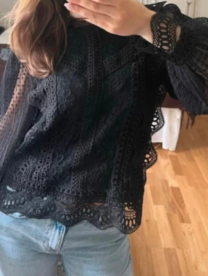 Svart spetsblus från Y.A.S - Supersnygg svart spetsblus från Y.A.S med långärmade transparenta ärmar och fina spets detaljer. Blusen har en vacker spets, perfekt att styla med jeans eller kjol. Materialet känns lätt och luftigt.