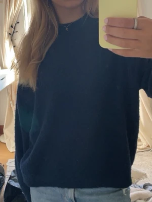 Mörkblå stickad tröja - En enkel och stilren mörkblå stickad tröja med rund hals och lång ärm. Perfekt för dig som gillar en klassisk look och vill ha något som funkar till det mesta. Tröjan har en relaxed passform och är lätt att matcha med både jeans och kjol. Bara att fråga för fler bilder 