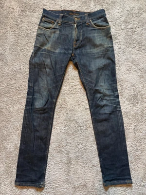 Nudie Jeans - Nudie Jeans Slim – begagnade Nudie Jeans slim jeans, storlek W29 L32 Begagnade men i bra skick – inga fläckar, revor eller blekta delar. Använda ca 5–10 gånger. Mått: •  Midjemått: 37 cm •  Innerbenslängd: 69 cm •  Bystlängd (total längd): 95 cm Perfekt passform! Autentiska, såklart. Nypris: 1899kr