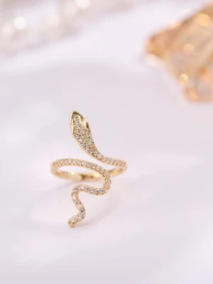 Guldfärgad ormring med stenar ifrån edblad  - Cool ring i form av en slingrande orm, guldfärgad och täckt med små glittrande stenar längs hela kroppen. Ringen har en öppen design som ger en unik och trendig look. Perfekt för dig som vill sticka ut med dina accessoarer.