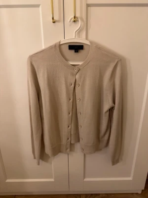 Beige kofta från Zara - En beige kofta från Zara med rund halsringning och knäppning framtill. Använd endast en gång.