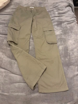 cargobyxor med vida ben - Stilrena  cargobyxor med raka, vida ben och stora fickor på sidorna. Byxorna har hällor för skärp och klassisk cargomodell. Perfekta för en avslappnad streetstyle-look.