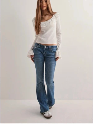Blå bootcut jeans från True Religion - Snygga blå bootcut jeans från True Religion med klassisk ljus tvätt och ikoniska bakfickor med kontrastsöm. Jeansen har låg midja. Säljer då dom är lite förstora för mig, annars jätte fina jeans!!