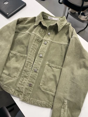 grön jeansjacka ZARA - Grön jeansjacka från ZARA, två stora bröstfickor och silverfärgade knappar framtill. Använt några gånger förra våren men inte särskilt mycket. Pris kan såklart diskuteras!!