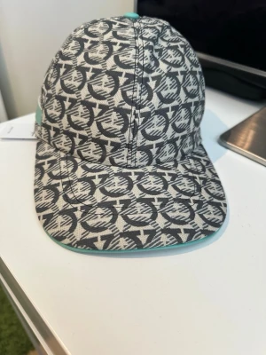 Ferregamo turkos keps  - Snygg keps från Salvatore Ferregamo som är med ljusblåa detaljer. Kepsen är helt ny och oanvänd. Pris kan såklart diskuteras, skriv vid frågor 