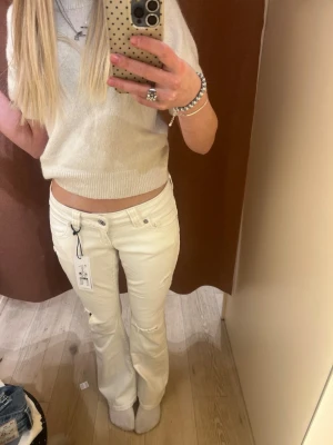 Vita bootcut jeans från Gina Tricot - Snygga vita bootcut jeans från Gina Tricot med slitna detaljer på benen och klassisk femficksdesign. Jeansen har låg midja. Storlek S i 14+ serien🙌🏻