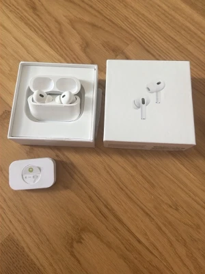 Apple AirPods Pro 2nd Gen vita - Säljer ett par vita Apple AirPods Pro (2nd generation) med laddningsetui. Trådlösa in-ear hörlurar med silikontoppar och stilren design. Kommer i originalförpackning med tillbehör. Perfekta för musik, samtal och träning.