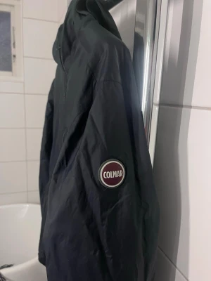 Svart och grön colmar windbreaker  - Säljer nu min Colmar Windbreaker jacka som är vändbar med ena sidan svart och andra sidan grön. Jackan har huva och två fickor med dragkedja på båda sidor. Den har inga skador och jag säljer den för att den är för liten. Skriv om du har några funderingar🤗