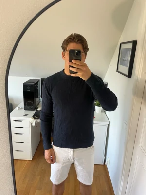 Mörkblå stickad tröja These glory days - Säljer en mörkblå stickad tröja från These glory days med rund halsringning och långa ärmar. Tröjan har en enkel, stilren design och är tillverkad i ett mjukt stickat bomull och viskos blandning. Hör gärna av dig vid frågor!